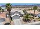 This home features lush palm trees, desert landscaping and a neutral color scheme at 818 Grape Vine Ave, Henderson, NV 89002