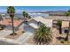 This house features beautiful palm trees, desert landscaping and a neutral color scheme at 818 Grape Vine Ave, Henderson, NV 89002