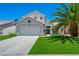 Charming two-story home with a well-manicured lawn, mature landscaping, and inviting curb appeal at 818 Grape Vine Ave, Henderson, NV 89002