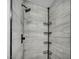 Shower featuring modern tile, black fixtures, and a convenient corner storage system at 818 Grape Vine Ave, Henderson, NV 89002