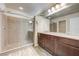 Bathroom featuring double sinks, a large mirror, and a glass-enclosed shower at 8565 Silver Coast St, Las Vegas, NV 89139