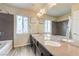 Bathroom features double sinks, marble countertops, light wood-look floors and window at 8565 Silver Coast St, Las Vegas, NV 89139