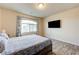 Bedroom featuring a bed, television, large window and light wood-look flooring at 8565 Silver Coast St, Las Vegas, NV 89139