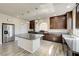 Gourmet kitchen features granite counters, stainless steel appliances, a center island, and dark wood cabinets with lots of light at 8565 Silver Coast St, Las Vegas, NV 89139