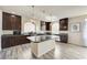 Spacious open kitchen featuring granite countertops, pendant lighting, stainless steel appliances, and dark wood cabinets at 8565 Silver Coast St, Las Vegas, NV 89139