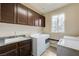 Convenient laundry room featuring ample cabinet space, granite countertop, sink, and washer/dryer at 8565 Silver Coast St, Las Vegas, NV 89139