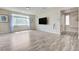 Sunlit living room with wood-look flooring, showcasing large windows and natural light at 8565 Silver Coast St, Las Vegas, NV 89139