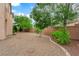 Lush backyard with gravel, stepping stones, and mature trees providing shade and privacy at 9614 Stonily Ln, Las Vegas, NV 89178