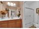 Bathroom featuring wood cabinets, double sink vanity, mirror, shower and toilet at 9614 Stonily Ln, Las Vegas, NV 89178