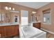Elegant bathroom with a soaking tub, dual vanities, and modern fixtures at 9614 Stonily Ln, Las Vegas, NV 89178