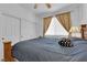 Cozy bedroom featuring a bed with a dark blue comforter, side table, and a window with curtains at 9614 Stonily Ln, Las Vegas, NV 89178