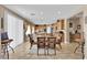 Well-lit dining room featuring a stylish glass table with seating for six, adjacent to a kitchen area at 9614 Stonily Ln, Las Vegas, NV 89178