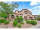 Beautiful two-story home featuring a two-car garage, arched entryway, and mature landscaping at 9614 Stonily Ln, Las Vegas, NV 89178