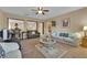 Open living room with neutral color palette, ceiling fan and carpet flooring at 9614 Stonily Ln, Las Vegas, NV 89178