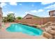 Inviting backyard pool with rock waterfall feature, perfect for relaxation and outdoor enjoyment under a bright sky at 9614 Stonily Ln, Las Vegas, NV 89178