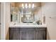 Bathroom vanity featuring a large mirror, modern lighting, and neutral countertops and cabinets at 9729 Hawk Crest St, Las Vegas, NV 89141