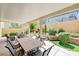 Covered patio with dining table, chairs, and a view of the landscaped backyard at 9729 Hawk Crest St, Las Vegas, NV 89141