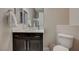 Bathroom featuring a dark vanity, sink, toilet, and towel rack at 334 Cougar Estates Ln, Las Vegas, NV 89123