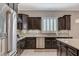 Modern kitchen featuring a stainless steel refrigerator, a cooktop, and ample counter space with dark cabinetry at 334 Cougar Estates Ln, Las Vegas, NV 89123