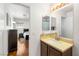 Bathroom vanity featuring light brown countertop and cabinets, a large mirror, and decorative tile backsplash at 10253 Martinsburg Ct, Las Vegas, NV 89183