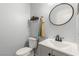 Modern powder room features a sleek vanity with a round mirror and stylish fixtures at 10253 Martinsburg Ct, Las Vegas, NV 89183