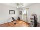 Bedroom with hardwood flooring and white walls featuring a window, bench and television at 10253 Martinsburg Ct, Las Vegas, NV 89183
