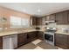 Well-lit kitchen features stainless steel appliances, dark wood cabinets, and mosaic tile backsplash at 10253 Martinsburg Ct, Las Vegas, NV 89183