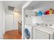 Upstairs laundry room with washer and dryer and white wire rack with laundry detergent and cleaning supplies at 10253 Martinsburg Ct, Las Vegas, NV 89183