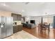 Open concept living space with hardwood floors seamlessly connecting to kitchen, dining, and seating areas at 10253 Martinsburg Ct, Las Vegas, NV 89183