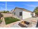 Private backyard featuring artificial grass, gravel landscaping, and a custom stone fire pit at 10613 Tiffanieville Ct, Las Vegas, NV 89129