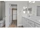 Well-lit bathroom with double vanity, framed mirror, and walk-in closet access at 10613 Tiffanieville Ct, Las Vegas, NV 89129