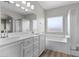 Luxurious bathroom boasts double sinks, a large mirror, and a soaking tub with tile surround at 10613 Tiffanieville Ct, Las Vegas, NV 89129