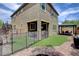 Landscaped backyard featuring a covered patio, artificial turf, safety fence, and a patio set at 1425 Overseer Ave, Henderson, NV 89074