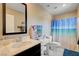 Bright bathroom featuring a vanity, sink, toilet, and a shower with a beach-themed curtain at 1425 Overseer Ave, Henderson, NV 89074