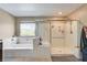 Modern bathroom with soaking tub, walk-in shower, and window with scenic views at 1425 Overseer Ave, Henderson, NV 89074