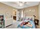 Bright bedroom featuring a ceiling fan, window, and a door to the on-suite bathroom at 1425 Overseer Ave, Henderson, NV 89074