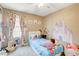 Charming bedroom featuring cartoon character murals, soft lighting, and a large window at 1425 Overseer Ave, Henderson, NV 89074