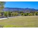 Expansive green space featuring a well-maintained lawn, walking path, and trees against a backdrop of mountains at 1425 Overseer Ave, Henderson, NV 89074