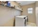 Functional laundry room featuring modern appliances, wire shelving, and a window for natural light at 1425 Overseer Ave, Henderson, NV 89074