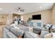 Cozy living room featuring sectional sofa, entertainment center, and open staircase at 1425 Overseer Ave, Henderson, NV 89074