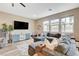 Comfortable living room featuring a large sofa, entertainment center, and multiple windows at 1425 Overseer Ave, Henderson, NV 89074