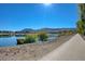 Scenic walking path along the tranquil lake, offering beautiful views of the water, mountains, and community at 1425 Overseer Ave, Henderson, NV 89074