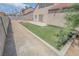 Fenced backyard with artificial turf and a stone patio at 2711 Sesame Dr, Las Vegas, NV 89142