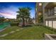Green backyard featuring a water view, palm trees, and manicured landscaping at 2925 Coast Line Ct, Las Vegas, NV 89117