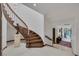 Elegant curved staircase with wood treads and white risers in a bright, open foyer near the outdoor pool at 2925 Coast Line Ct, Las Vegas, NV 89117