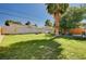 Expansive backyard with lush green lawn, mature trees, and a stone barbecue island, great for outdoor living at 3013 Roseville Way, Las Vegas, NV 89102