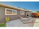 Cozy outdoor patio with a hammock, dining area, and stylish gray siding, ideal for relaxing and entertaining at 3013 Roseville Way, Las Vegas, NV 89102