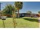 View of the backyard featuring a grassy lawn, trees, and a modern home with a garden area at 3013 Roseville Way, Las Vegas, NV 89102