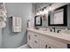 Bathroom featuring a double sink vanity with marble countertop, dark hardware, and stylish vanity lighting at 3013 Roseville Way, Las Vegas, NV 89102
