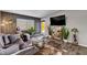 A cozy living room that is bright and includes a flat screen television, plants, and artwork at 3013 Roseville Way, Las Vegas, NV 89102